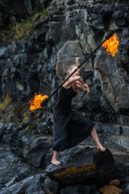 Alevli meşalelerle siyah elbiseli kız .