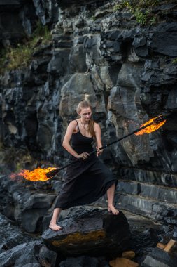 Alevli meşalelerle siyah elbiseli kız .