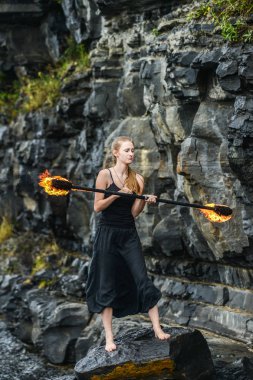 Alevli meşalelerle siyah elbiseli kız .