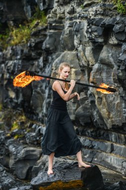 Alevli meşalelerle siyah elbiseli kız .