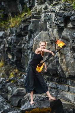 Alevli meşalelerle siyah elbiseli kız .