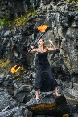 Alevli meşalelerle siyah elbiseli kız .