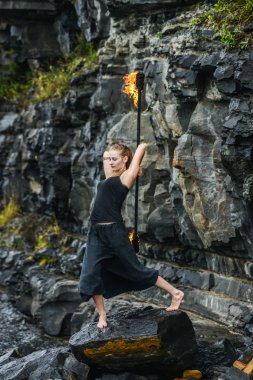 Alevli meşalelerle siyah elbiseli kız .