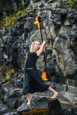 Alevli meşalelerle siyah elbiseli kız .