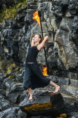 Alevli meşalelerle siyah elbiseli kız .