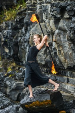 Alevli meşalelerle siyah elbiseli kız .