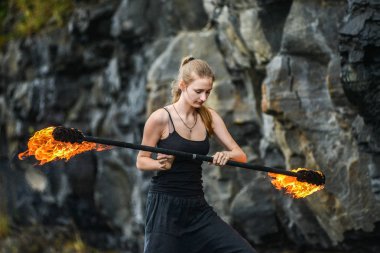 Alevli meşalelerle siyah elbiseli kız .