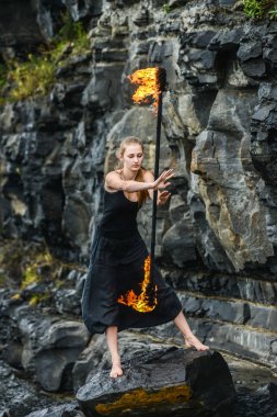 Alevli meşalelerle siyah elbiseli kız .