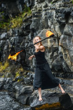 Alevli meşalelerle siyah elbiseli kız .