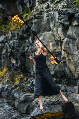 Alevli meşalelerle siyah elbiseli kız .