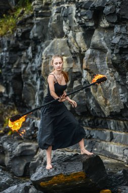 Alevli meşalelerle siyah elbiseli kız .