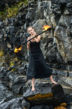 Alevli meşalelerle siyah elbiseli kız .