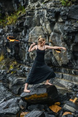 Alevli meşalelerle siyah elbiseli kız .