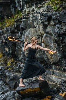 Alevli meşalelerle siyah elbiseli kız .