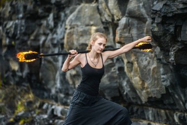 Alevli meşalelerle siyah elbiseli kız .