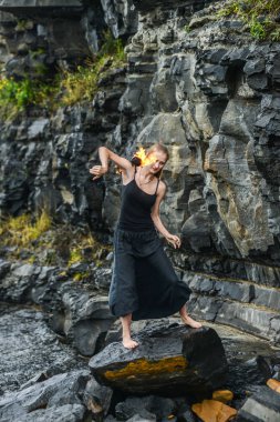 Alevli meşalelerle siyah elbiseli kız .