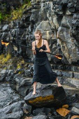 Alevli meşalelerle siyah elbiseli kız .