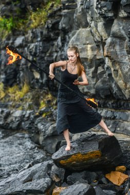 Alevli meşalelerle siyah elbiseli kız .