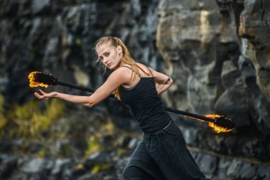 Alevli meşalelerle siyah elbiseli kız .