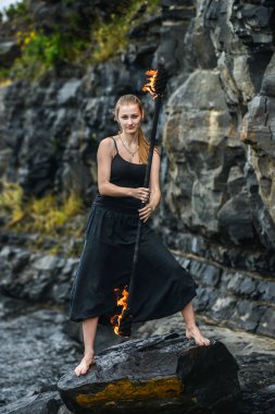 Alevli meşalelerle siyah elbiseli kız .