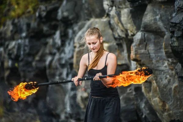 Girl in a black suit with flaming torches . — Stock Photo, Image