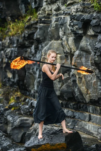 Alevli meşalelerle siyah elbiseli kız .