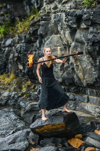 Alevli meşalelerle siyah elbiseli kız .