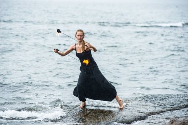 Alevli meşalelerle siyah elbiseli kız .