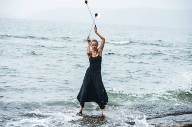 Alevli meşalelerle siyah elbiseli kız .