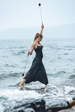 Alevli meşalelerle siyah elbiseli kız .