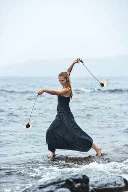 Alevli meşalelerle siyah elbiseli kız .