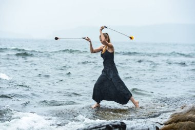 Alevli meşalelerle siyah elbiseli kız .