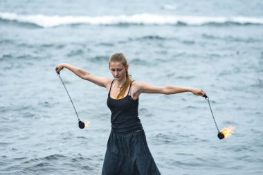 Alevli meşalelerle siyah elbiseli kız .