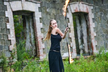 Alevli meşalelerle siyah elbiseli kız .