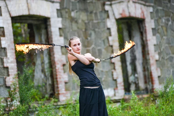 Girl in a black suit with flaming torches . — Stock Photo, Image