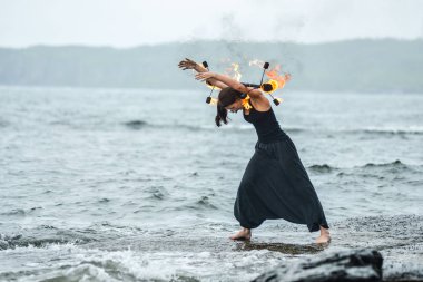 Deniz kıyısında ateş gösterisi ile oynamak