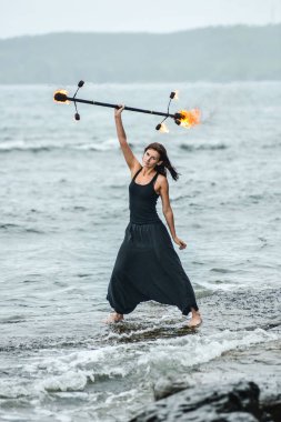 Deniz kıyısında ateş gösterisi ile oynamak