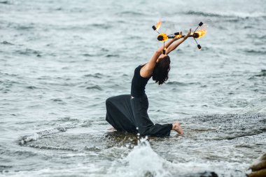 Deniz kıyısında ateş gösterisi ile oynamak