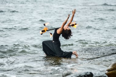 Deniz kıyısında ateş gösterisi ile oynamak