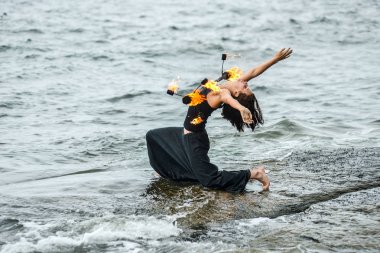 Deniz kıyısında ateş gösterisi ile oynamak