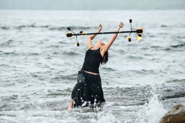 Deniz kıyısında ateş gösterisi ile oynamak