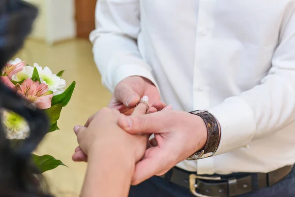 Huwelijk handen met ringen. birde draagt de ring aan de vinger van de bruidegom — Stockfoto