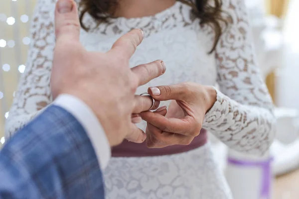 Huwelijk handen met ringen. birde draagt de ring aan de vinger van de bruidegom — Stockfoto