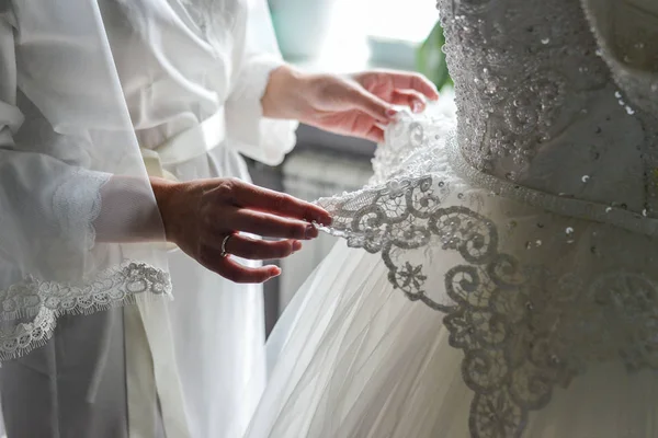 抱着新娘婚纱礼服伴娘 — 图库照片