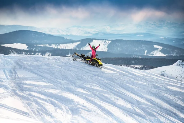 Jinete en la moto de nieve en las montañas — Foto de Stock