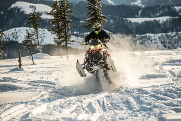 Cavaleiro na moto de neve nas montanhas. unidade ativa — Fotografia de Stock