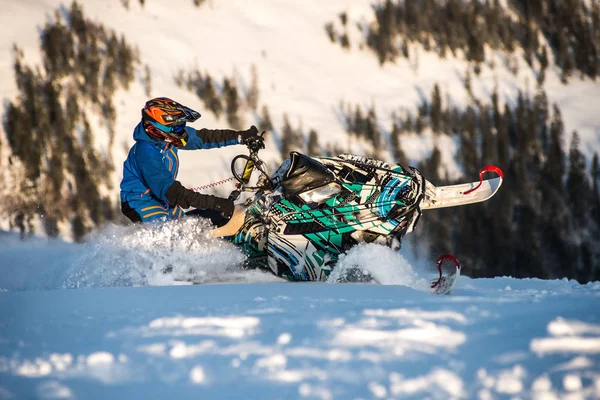 Jinete en la moto de nieve en las montañas. unidad activa —  Fotos de Stock