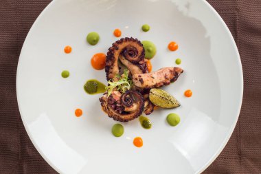 Beyaz bir plaka üzerinde pişirilmiş ahtapot yakın çekim