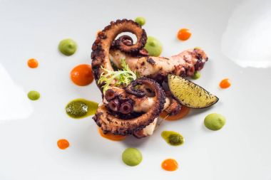 Beyaz bir plaka üzerinde pişirilmiş ahtapot yakın çekim