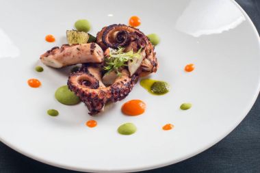 Beyaz bir plaka üzerinde pişirilmiş ahtapot yakın çekim